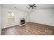 Bright living room with modern ceiling fan, fireplace, and wood-look flooring at 10130 Illoria Dr, Charlotte, NC 28273