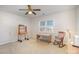 A bedroom with a desk, rocking chair, and light neutral-colored carpet and walls at 10502 Orchid Hill Ln, Charlotte, NC 28277