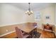 Inviting dining room with traditional wainscoting, hardwood floors, and a modern chandelier at 10502 Orchid Hill Ln, Charlotte, NC 28277