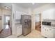 Open kitchen with stainless steel fridge, white cabinets, and tile flooring at 10502 Orchid Hill Ln, Charlotte, NC 28277