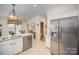 Well-lit kitchen featuring stainless steel appliances, tile floors and white cabinetry at 10502 Orchid Hill Ln, Charlotte, NC 28277