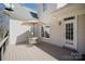 Outdoor patio area with a table, chairs, and an umbrella for shade and a door to the interior at 10502 Orchid Hill Ln, Charlotte, NC 28277