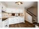 Well-lit kitchen showcasing white cabinets, countertops, appliances, and a view of the stairs at 10961 Carmel Crossing Rd, Charlotte, NC 28226