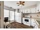Functional kitchen featuring white cabinets, a stove, refrigerator, and a window for natural light at 10961 Carmel Crossing Rd, Charlotte, NC 28226