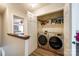 Convenient laundry room with modern side-by-side washer and dryer, plus shelving for storage at 10961 Carmel Crossing Rd, Charlotte, NC 28226
