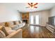 Cozy living room featuring a brick fireplace, comfortable seating, and wood-look flooring at 10961 Carmel Crossing Rd, Charlotte, NC 28226
