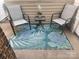 Relaxing outdoor patio with two chairs, a small table, and a decorative floral rug at 10961 Carmel Crossing Rd, Charlotte, NC 28226