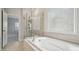 Bright bathroom featuring a soaking tub, walk-in shower, and tile flooring at 1439 Hubert Graham Way, Tega Cay, SC 29708