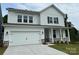 Charming two-story home showcasing a white exterior, two-car garage, and inviting front porch with stone accents at 1439 Hubert Graham Way, Tega Cay, SC 29708