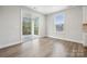 Bright living room features wood floors, a window, and sliding glass door to outdoor space at 1439 Hubert Graham Way, Tega Cay, SC 29708