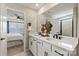 Bright bathroom features a double vanity with white cabinets and black hardware, offering a sleek modern design at 15212 Caspian Way, Charlotte, NC 28278