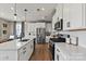 This bright kitchen features stainless steel appliances, white cabinets, and hardwood floors at 15212 Caspian Way, Charlotte, NC 28278
