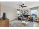 Cozy living room with a plush blue sectional sofa, accent pillows, and a ceiling fan at 15212 Caspian Way, Charlotte, NC 28278