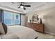 Inviting main bedroom with natural light, a tray ceiling, and a wooden dresser at 15212 Caspian Way, Charlotte, NC 28278