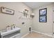 Well-lit mudroom with custom pet themed decor, tiled flooring, cabinetry, and organized shelving at 15212 Caspian Way, Charlotte, NC 28278