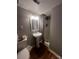 Functional bathroom features a shower, toilet, and pedestal sink, providing essential amenities in a compact space at 1608 Van Dyke Dr, Charlotte, NC 28213