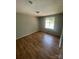 Well-lit bedroom with laminated flooring, a large window, and neutral walls creates a serene and inviting space at 1608 Van Dyke Dr, Charlotte, NC 28213