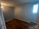 Bedroom featuring natural light from window, gray walls, and wood-look floors at 1608 Van Dyke Dr, Charlotte, NC 28213