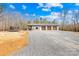 Spacious garage with multiple bays and a large gravel driveway surrounded by trees and a playground at 164 Linderman Lake Ln, Kings Mountain, NC 28086