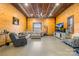 Spacious living room featuring wood walls, concrete floors, a ceiling fan, and comfortable seating at 164 Linderman Lake Ln, Kings Mountain, NC 28086