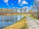 Scenic pond with a driveway, trees, and a building in the distance at 164 Linderman Lake Ln, Kings Mountain, NC 28086