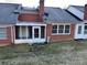 Rear view of brick home featuring a screened porch and yard at 19915 Oak Leaf Cir, Cornelius, NC 28031
