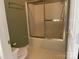 Functional bathroom with a toilet and shower-tub featuring sleek sliding glass doors and neutral decor at 19915 Oak Leaf Cir, Cornelius, NC 28031