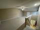 View from top of stairs into large carpeted bonus room with ceiling fan and white door at 19915 Oak Leaf Cir, Cornelius, NC 28031