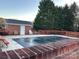 Inviting outdoor pool area with a covered pool, patio space, and lush landscaping for relaxation at 19915 Oak Leaf Cir, Cornelius, NC 28031