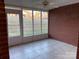 Enclosed sunroom with brick walls, tile floors, white-framed windows, and view of backyard at 19915 Oak Leaf Cir, Cornelius, NC 28031