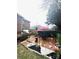 Serene backyard with deck, hot tub, and manicured landscaping featuring white gravel, flamingo statues, and flowering plants at 205 Edenshire Ct, Indian Trail, NC 28079