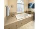 Bright bathroom showcases a tub with tile surround and a window that brings in natural light at 205 Edenshire Ct, Indian Trail, NC 28079