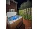 Inviting hot tub with illuminated jets and wooden surround, set against a backdrop of greenery and fairy lights at 205 Edenshire Ct, Indian Trail, NC 28079