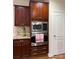 Well-equipped kitchen featuring stainless steel microwave and oven, granite countertops, and rich wooden cabinets at 205 Edenshire Ct, Indian Trail, NC 28079