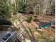 Backyard showcasing a wooden deck with a slide, stairs, grill and mature trees at 215 Biscoe Rd, Troy, NC 27371