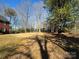 Expansive backyard surrounded by mature trees, providing shade and privacy at 215 Biscoe Rd, Troy, NC 27371