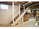 Basement stairs with a wooden handrail and a concrete floor at 215 Biscoe Rd, Troy, NC 27371