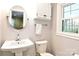 Bright bathroom featuring a pedestal sink and a round mirror at 215 Biscoe Rd, Troy, NC 27371