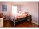 Pink bedroom with hardwood floors and pink bedding at 215 Biscoe Rd, Troy, NC 27371