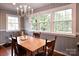 Bright dining room with hardwood floors, a chandelier, and large windows offering natural light at 215 Biscoe Rd, Troy, NC 27371