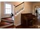 Bright entryway with hardwood floors, staircase, piano, and a cat by the window at 215 Biscoe Rd, Troy, NC 27371