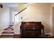 Inviting entryway features a wooden staircase, piano, and a friendly feline companion at 215 Biscoe Rd, Troy, NC 27371