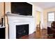 Cozy living room with fireplace, mounted TV, and hardwood floors, showcasing comfortable living at 215 Biscoe Rd, Troy, NC 27371