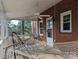 Relaxing covered porch featuring a hammock, ceiling fan and brick exterior at 215 Biscoe Rd, Troy, NC 27371