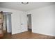 Bright bedroom with light colored walls and wood-look floors has an attractive sliding wooden door to the bathroom at 244 Stilwell Oaks Cir, Charlotte, NC 28212