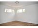 Minimalist bedroom with three windows and wood-look floors at 244 Stilwell Oaks Cir, Charlotte, NC 28212
