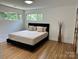 Main bedroom featuring light hardwood floors, large windows, and modern finishes at 244 Stilwell Oaks Cir, Charlotte, NC 28212