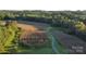 Expansive aerial view of farmland, featuring lush greenery and a winding path, perfect for outdoor enthusiasts at 3032 Morning Glory Ln, Vale, NC 28168