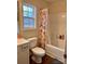 Bright bathroom featuring a shower-tub combination with patterned curtain and a window at 3032 Morning Glory Ln, Vale, NC 28168