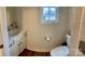 Bright bathroom featuring a white vanity, toilet, and window at 3032 Morning Glory Ln, Vale, NC 28168